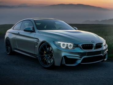 夕日を背景に駐車しているシルバーのスポーツカーです